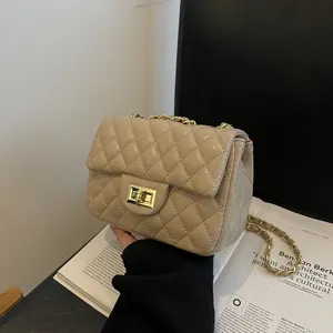 Elegante gesteppte Damen Umhängetasche aus beige Kunstleder mit Kette und modischem Schloss.