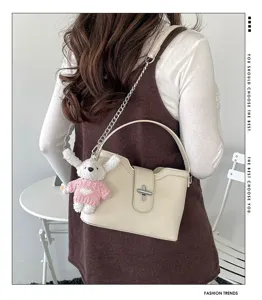 Vue détaillée du sac seau élégant en cuir grainé avec bandoulière chaîne et charm lapin en peluche.