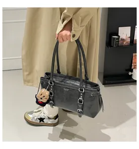 Stylish dark grey shoulder tote bag with dual straps and chic metal buckle decor.