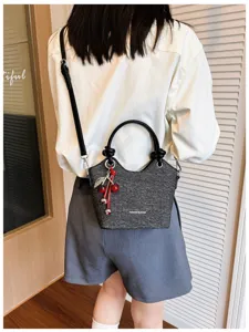 Chic casual women's shoulder bag with cherry charm, stylish commuting bucket bag for daily wear.