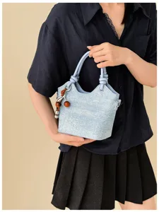 Chic denim style bucket bag for women, trendy commuter handbag with cute cherry charm accessory.