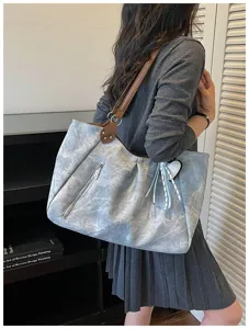 Large capacity grey shoulder tote bag detail view showcasing brown handles and side zipper pocket.