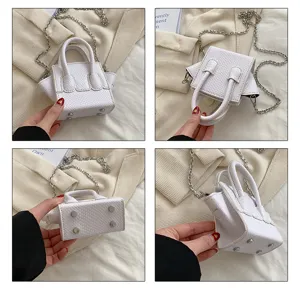 White mini handbag with snake pattern, top handles and silver chain strap detail.