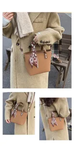 Detail shot of brown textured tote bag with chic scarf handle, lifestyle outdoor setting.