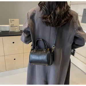 Black Boston pillow handbag for women, stylish crossbody and shoulder bag with top handles.