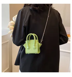 Green textured mini handbag detail view, stylish crossbody chain bag for modern women fashion.