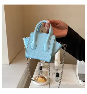 Fashionable light blue mini snakeskin tote bag with chain strap, stylish and chic design.