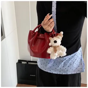 Red retro PU leather handbag with cute fluffy bear charm, stylish women's shoulder bucket bag detail.