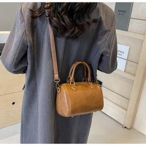 Detail view of the brown leather Boston shoulder bag showcasing refined metal hardware.