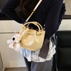 Stylish women bucket bag vintage PU leather shoulder crossbody bag with cute bear pendant.