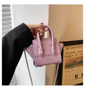 Detail shot of the elegant purple mini snakeskin handbag with metal chain strap.