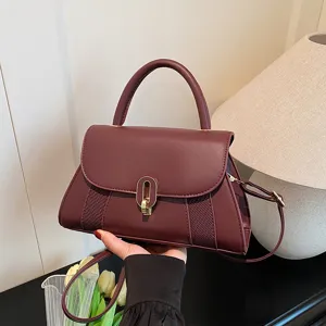 Burgundy leather handbag for women, stylish top handle shoulder bag with metal lock closure.