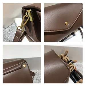 Brown leather cylinder shoulder bag detail showing premium metal hardware and cute plush doll pendant.