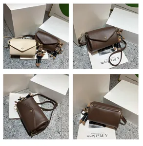 Detailed showcase of stylish cylinder crossbody bag details, featuring cute charm and flap closure.
