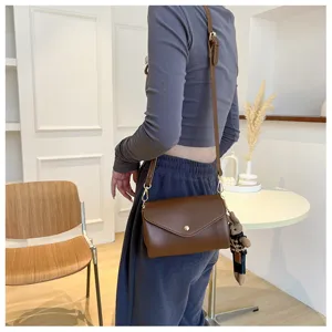 Detailed shot of women brown crossbody bag with plush charm, casual daily style view.