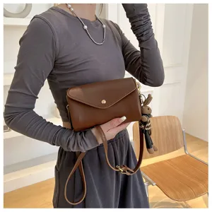 Brown PU leather crossbody bag with flap, metal snap closure and cute rabbit charm detail.