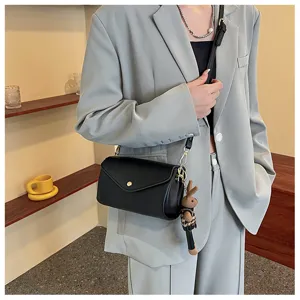 Black leather shoulder bag with chic knit bunny pendant for women stylish daily commute wear