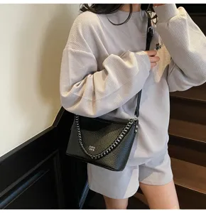 Schwarze leder eimer tasche für frauen, stilvolle umhängetasche mit kette und henkel.