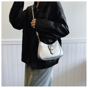 Dettaglio borsa a spalla metallica argentata, fibbia retro, borsa casual giornaliera.