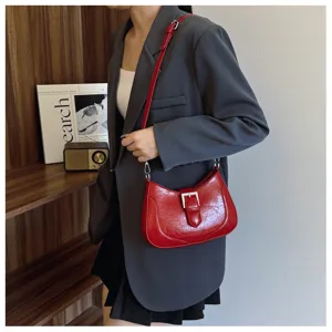 Elegante borsa a spalla rossa in vernice con fibbia chic, accessorio trendy per donna.