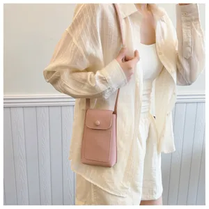 Pink leather crossbody phone bag detailed view showing soft texture, flap closure and slim strap.