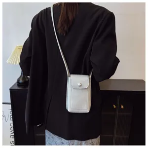 Close up detail view of women soft leather silver crossbody phone bag, elegant daily mini purse.