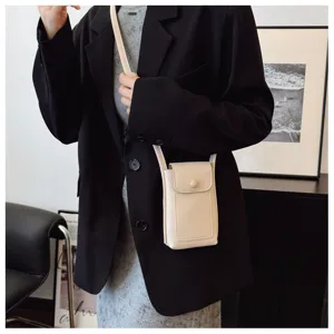 Detail view of women's soft leather crossbody phone bag, minimalist beige mini shoulder bag.