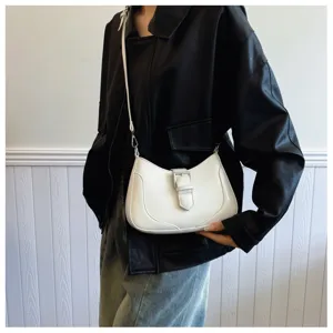 Vista dettagliata di una elegante borsa a spalla bianca con fibbia e design chic.