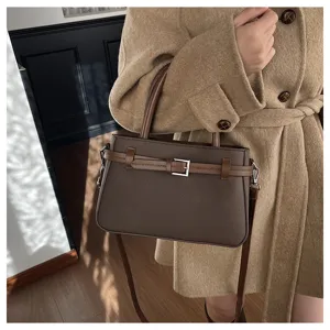 Close-up detail of the vintage brown women's handbag with stylish center belt buckle.