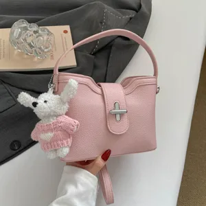 Sac seau rose élégant à motif litchi avec poignée et charmant pendentif chiot pour femmes.