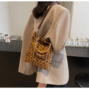 Stylish leopard print fabric shoulder bag featuring unique curved natural bamboo handles.