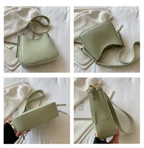 Detail view of light green minimalist crescent shoulder bag, featuring PU leather and hardware.