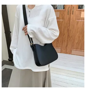 Close-up view of the minimalist black shoulder bag showcasing its clean design and premium strap.