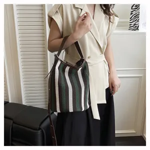 Vista dettagliata della borsa a secchiello a righe alla moda con design in maglia traforata.