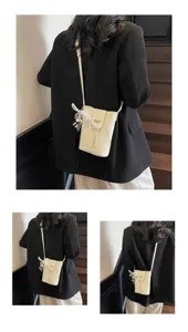 Crossbody mini bucket bag detail view, compact vertical phone bag with pearl charm.