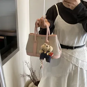 Canvas tote bag with pink leather trim and cute bear keychain, stylish shoulder handbag for women