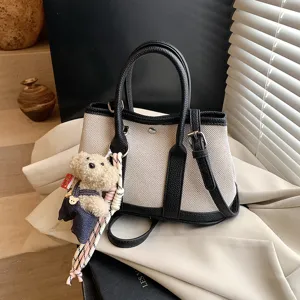 Chic canvas contrast tote bag for women, large capacity shoulder handbag with cute bear charm.