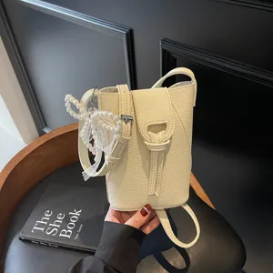 Compact crossbody phone bag mini bucket bag with pearl pendant, lightweight daily leather purse.