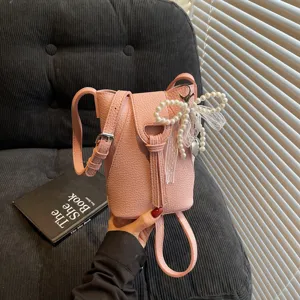 Women crossbody mini bucket bag, cute pink leather phone purse with pearl bow charm.