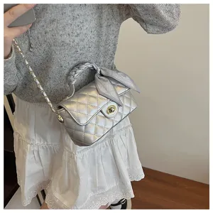 Chic silver quilted chain shoulder bag detail showcasing elegant twist lock and scarf decoration.