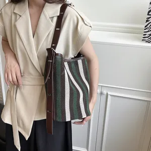 Grande borsa a tracolla a righe e traforata, elegante borsa a mano alla moda per donna.