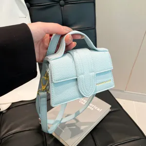 Chic light blue leather mini handbag with top handle and crossbody strap for women daily stylish look.