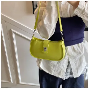 Detail shot of stylish lime green underarm shoulder bag with metal lock clasp and strap.