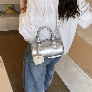 Silver metallic cylindrical shoulder bag trendy barrel crossbody bag with cute plush charm.