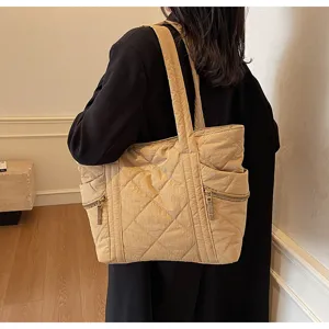 Detailed view of the quilted tote bag featuring diamond pattern stitching and side zipper pocket.