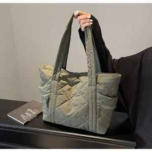 Detailed view of green quilted tote bag with soft fabric, shoulder straps and side pockets.