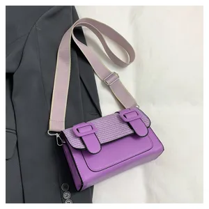 Detail shot of a stylish purple contrast crossbody satchel bag with wide strap and buckle accent.