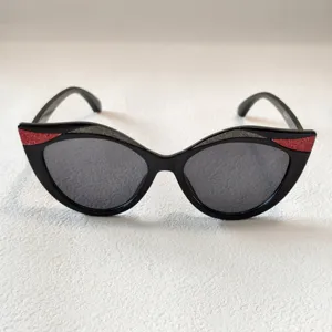 Kinder Sonnenbrille im schicken Katzenaugen-Design mit Glitzer, schwarzer Rahmen outdoor.