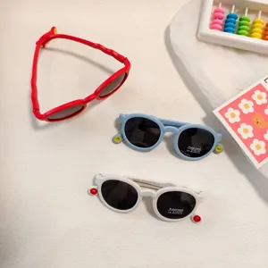Details of polarized kids sunglasses with colorful frames and cute round decor, close-up shot.