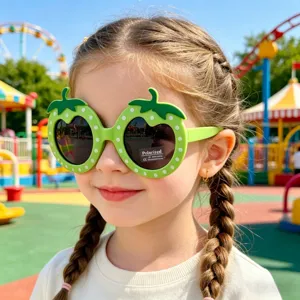 Close-up detail of cute green strawberry cartoon polarized children sunglasses park.